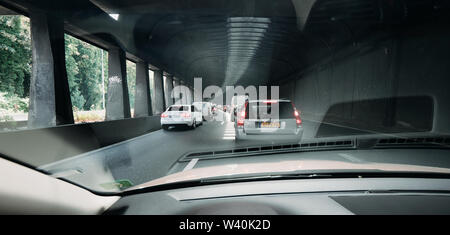 Paris, France - Jul 15, 2018: Wide image POV personal perspective and the front driving Volvo V70 car in traffic jam exiting the tunnel of Boulevard peripherique in Paris, France Stock Photo