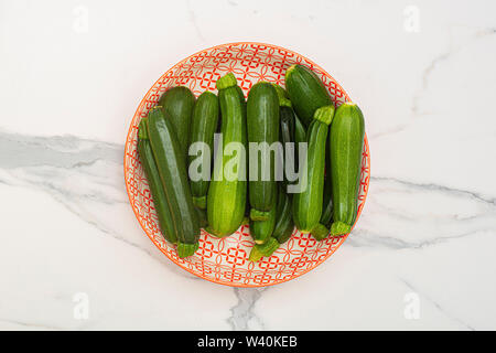 Bowl of green courgettes in various sizes Stock Photo
