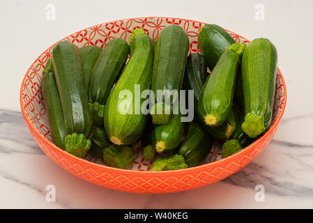 Bowl of green courgettes in various sizes Stock Photo