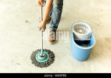 Man worker with mop cleaning floor in the cafe Stock Photo