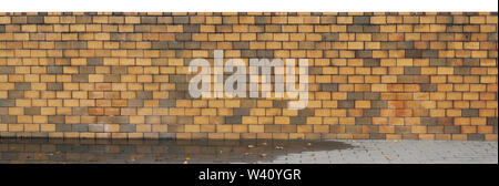 Long fence  from yellow burned clay bricks panoramic fragment. Isolated on top Stock Photo