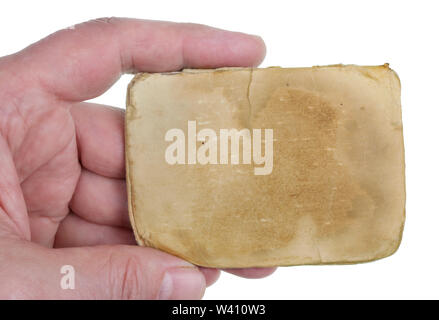 A man holds in his hand a sheet of yellowed old paper from an ancient notebook. Isolated on white studio macro Stock Photo