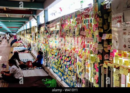 Domestic Workers resting next to Lennon Walls at Mong Kok Station , Hong Kong, July 2019 Stock Photo