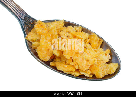 In the old golden spoon there is a small pile of food - pieces of dried mexican corn tortillas with salt and chili . Isolated on white studio macro Stock Photo