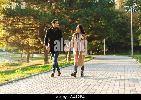 Image of a happy young beautiful loving couple posing walking outdoors in park nature. Stock Photo