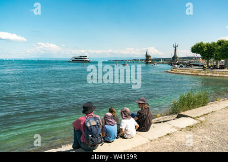 Konstanz, BW / Germany - 14. July 2019: tourists enjoy a beautiful summer day on the shores of Lake Constance with ships passing by Stock Photo