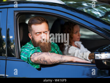A bearded man with his girlfriend in the car Stock Photo