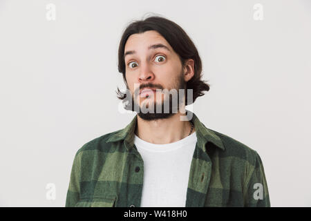 Portrait of a confused surprised young bearded brunette man wearing plaid shirt standing isolated over white background Stock Photo