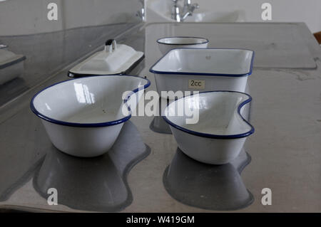Enamel kidney dishes on a stainless steel work top in a dental laboratory. Stock Photo