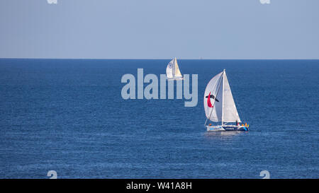 Egmond aan Zee, Netherlands - July 18, 2019: two sailing boats on the North Sea in sunlight Stock Photo