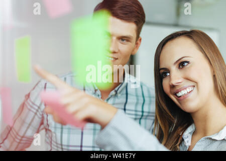 Two happy employees working together in the office Stock Photo