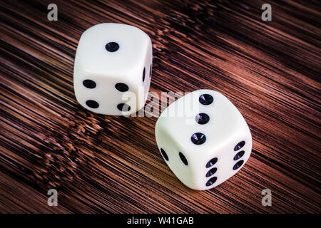 White dice isolated on bamboo grain textured background Stock Photo