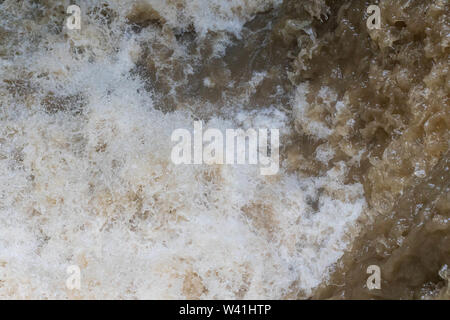 Overhead view of fast flowing brown water in flooding event Stock Photo