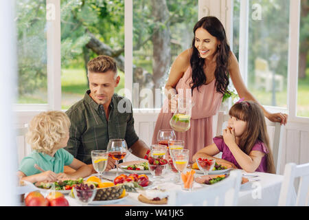 Mommy smiling while pouring lemonade for her daughter Stock Photo