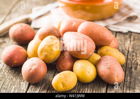 Fresh potatoes. Raw potatoes on old wooden table. Stock Photo