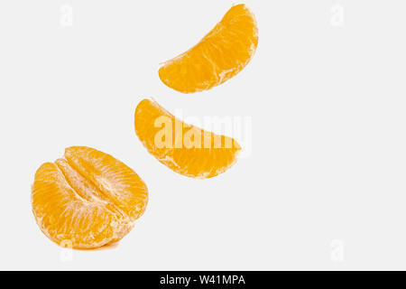 Falling mandarin slices on a white background Stock Photo