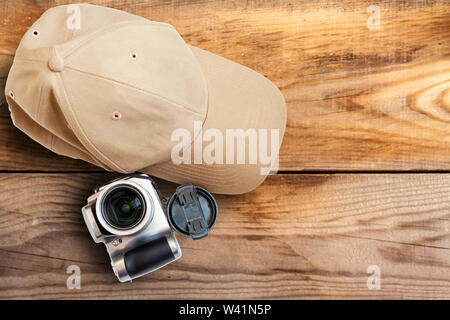 Baseball cap camera on a wooden background close-up. Stock Photo