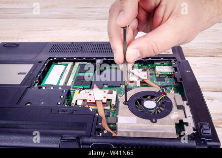 Unscrew the laptop fan to repair it. Stock Photo