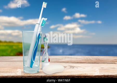 Toothbrushes manual electric in a glass on the counter on the background of the pool Stock Photo
