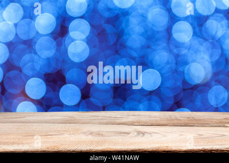 Wooden planks on the background of defocused abstract background of Christmas multi-colored light bulbs. Stock Photo