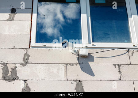 Surveillance camera hanging on the wall at home. Stock Photo