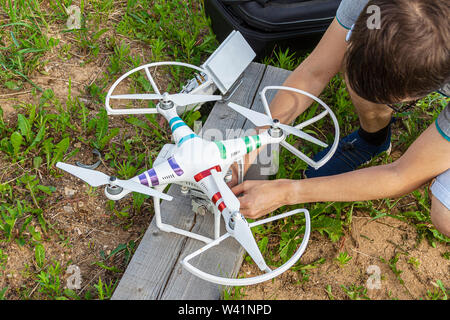 Kaluga, Russia 06/02/2019 A man prepares for flight a quadrocopter checks its serviceability. Stock Photo