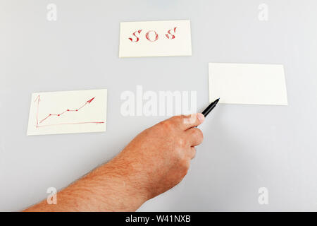 A hand holds a pen and shows on a blank sticker. Template. Stock Photo