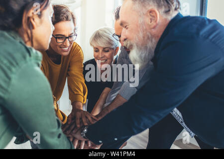 Successful business people hands stacked together. Business team showing unity. Stock Photo