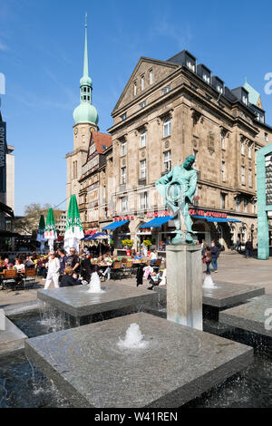 Dortmund, Germany: Blaeserbrunnen (horn blower fountain) on the 'old market place' with the Adler pharmacy and the Protestant church St. Reinoldi in the background.    ---   Dortmund: Blaeserbrunnen auf dem 'Alter Markt' mit der Adler Apotheke und der evangelischen Stadtkirche St. Reinoldi im Hintergrund. Stock Photo