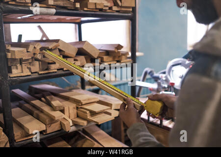 Carpenter selecting a board testing its quality for wood work. Stock Photo