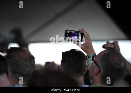 An audience member takes a pictures of George Ezra as he plays a secret set to mark the 10th anniversary of the Barn on the Farm Music festival Stock Photo