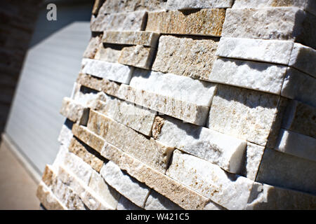 Stone tile blocks close up on a pillar with the details of sand and rough surface with a blurred background Stock Photo