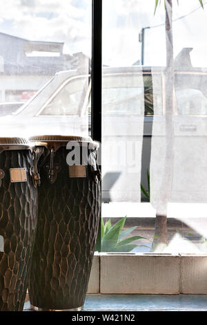 Bongo drums in a room beside glass windows, music instruments in a room Stock Photo