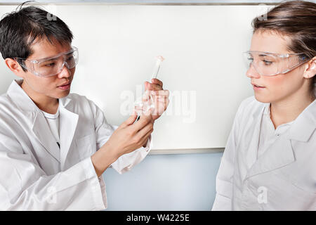 Medical Students look at a beaker and thinking of getting a decision in a lab Stock Photo