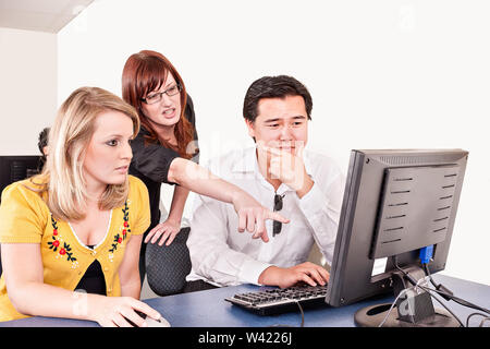 Girl shows a guy something on a computer screen in an office Stock Photo