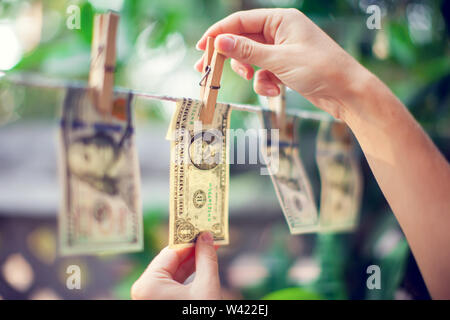 US dollar banknotes hanging on rope for money laundering conept hand collect money Stock Photo