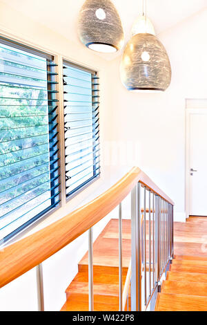 Brown wooden stairs with lamp and wall, colorful two lamps can see on ceiling, perfect lights balance, very clean place, door is locked and white colo Stock Photo