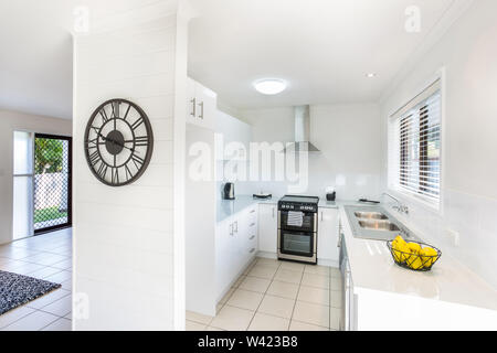 Stunning kitchen area view with chimney and oven along with the exit door in the living room Stock Photo