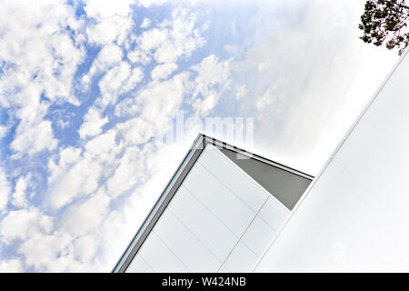 Modern building roof view with white clouds and blue sky as an angled shot which showed the parts of the walls Stock Photo