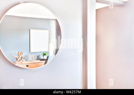 Round mirror glass on the wall close up in a modern house or hotel with the sunlight illumination, the reflection included a 3d letter beside a photo Stock Photo