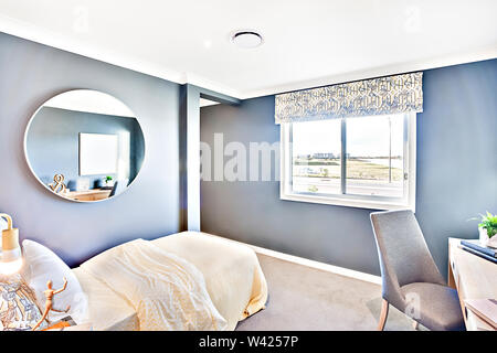 Classic room at daytime with sunlight illumination and environment. The round mirror on the wall beside the window curtain next to chair and table, a Stock Photo