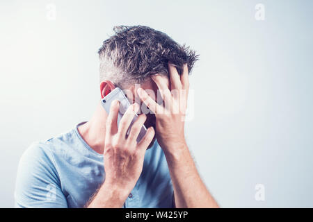Handsome young man using mobile phone feel sad Stock Photo