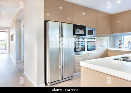 https://l450v.alamy.com/450v/w4266a/expensive-and-modern-kitchenware-including-silver-color-and-tall-two-door-refrigerator-and-four-ovens-and-stoves-fixed-to-the-wall-with-cabinets-aroun-w4266a.jpg