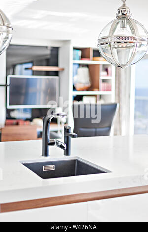 A minimalist counter-top basin with hanging pendant lights Stock Photo