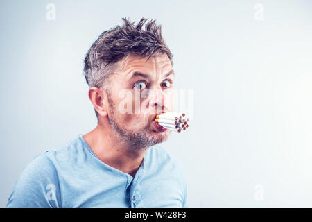 Young man with many cigarettes in his mouth Stock Photo