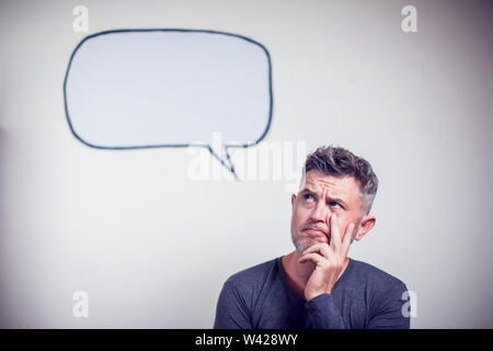Portrait of a young man with a empty speech bubble over his head Stock Photo