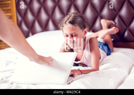 Computer addiction - mother taking computer from the child Stock Photo