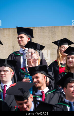 Higher education in the UK - successful students at the graduation ceremony at Aberystwyth university, after receiving their degrees,  wearing their traditional caps and gowns. July 2019