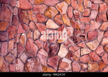 Part of a red stone wall, for background or texture. Stock Photo