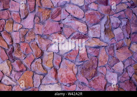 Part of a red stone wall, for background or texture. Stock Photo